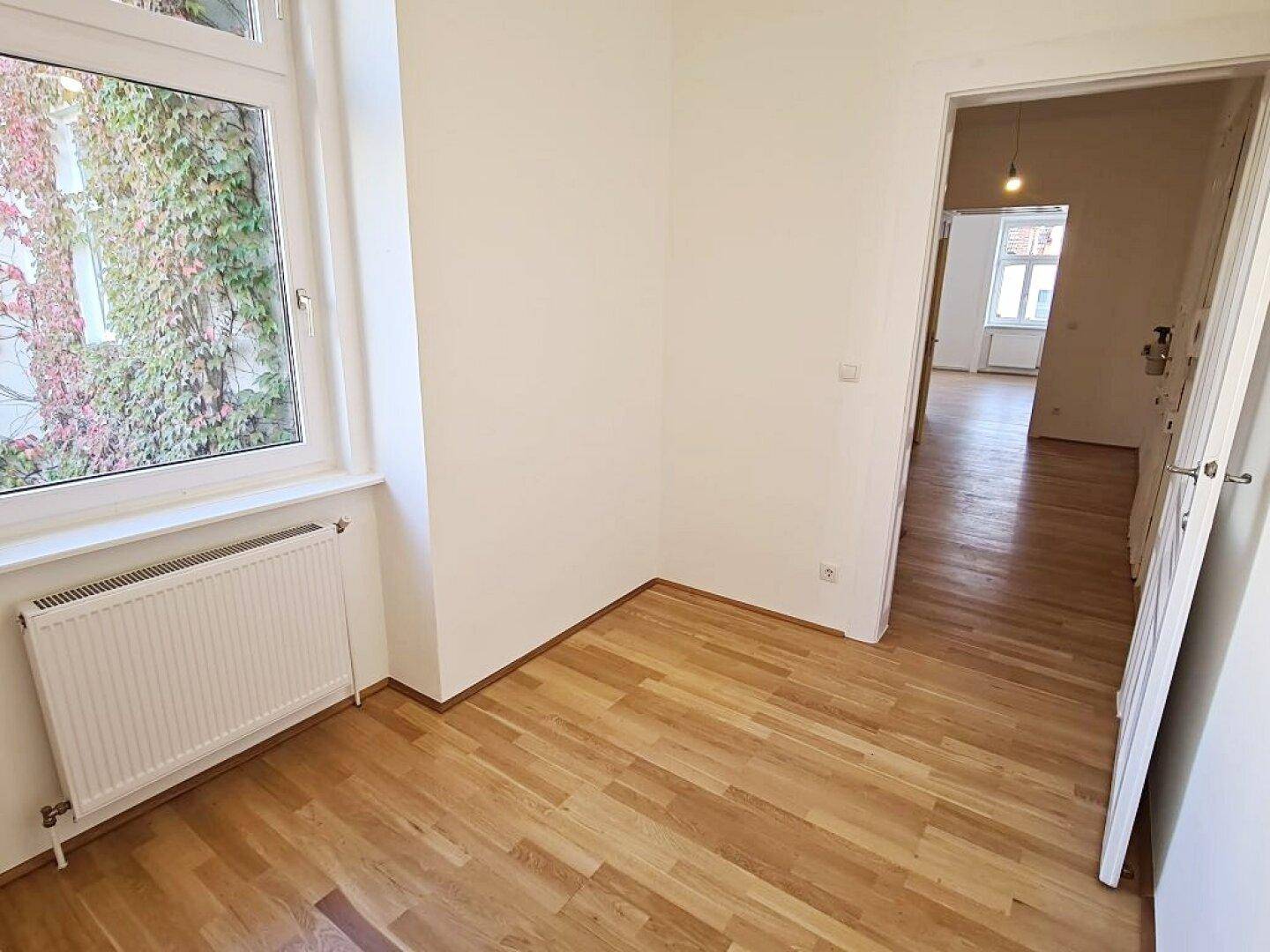 Gemütliches Zimmer mit Parkettboden und Blick ins Grüne, ideal als ruhiges Schlafzimmer.