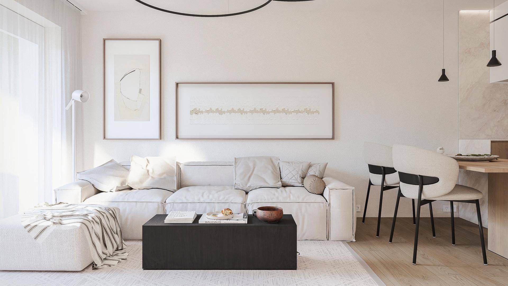 Helles und modern eingerichtetes Wohnzimmer mit beigem Sofa, Kunstwerken und viel Tageslicht.