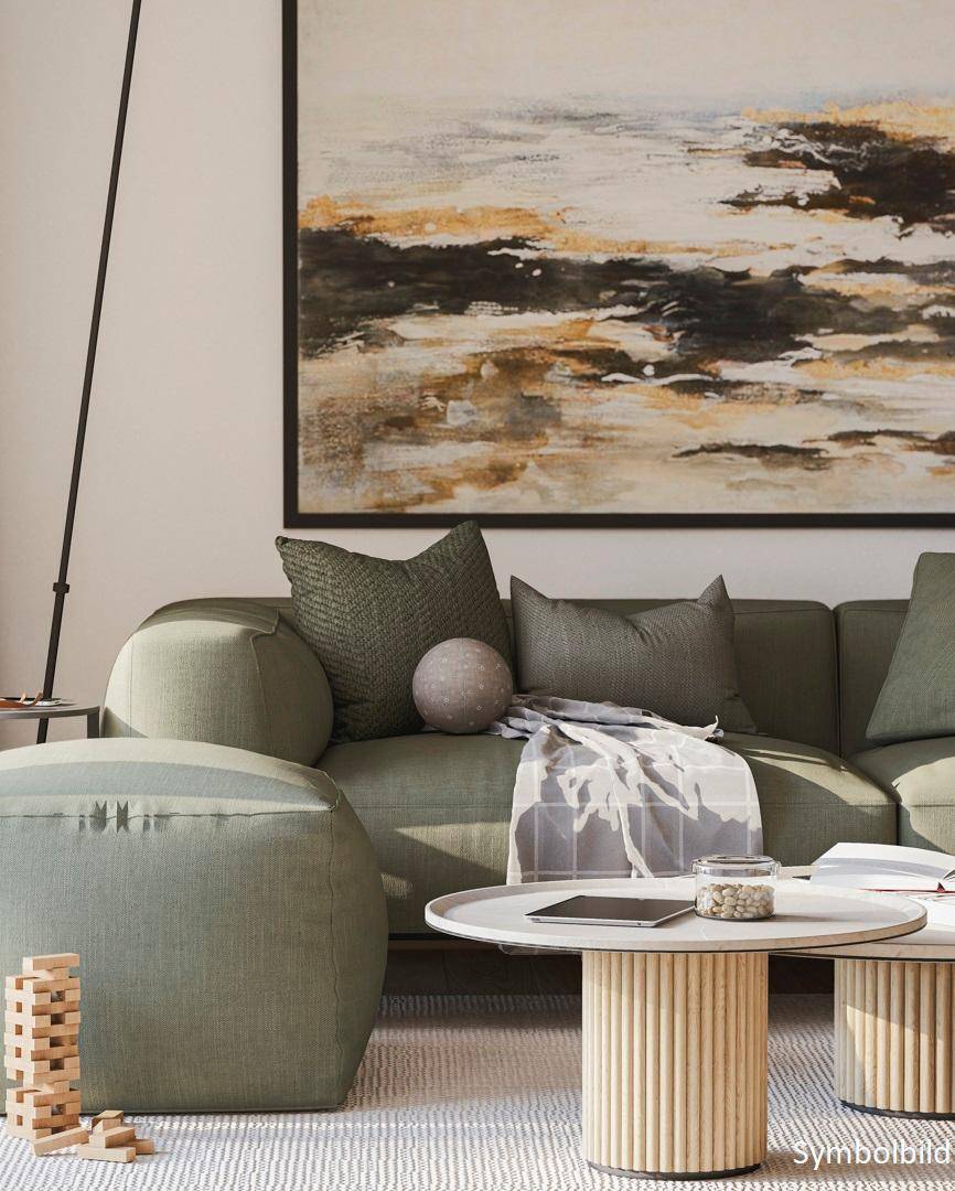 Gemütliche Sitzecke mit grünem Sofa, modernen Couchtischen und abstrakter Kunst an der Wand.