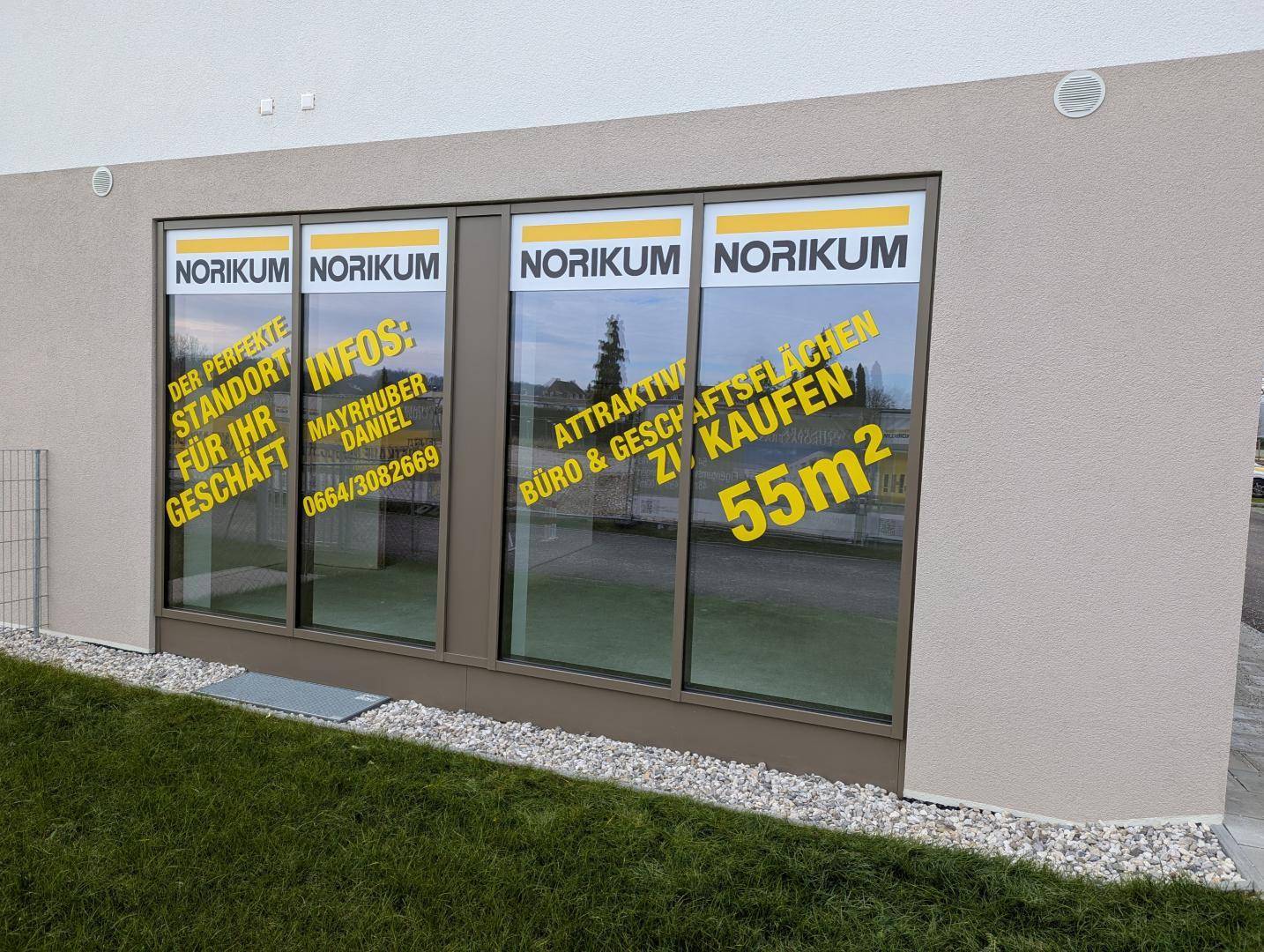 Seitenansicht einer modernen Gewerbefläche mit großen Fenstern und Werbehinweisen auf 55 m².