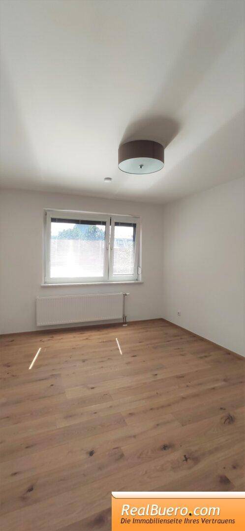 Freundliches Zimmer mit hellem Parkettboden und Fenster, ideal als Schlaf- oder Arbeitszimmer nutzbar.