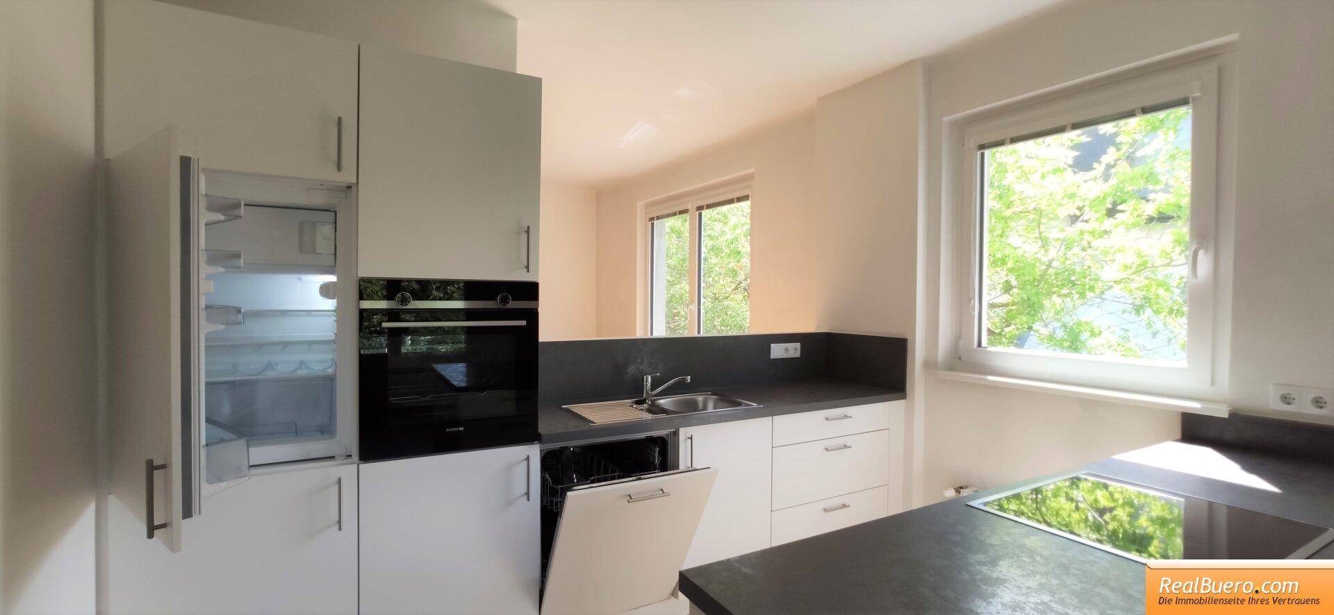 Einbauküche mit Kühlschrank, Backofen und Geschirrspüler, hell und funktional.