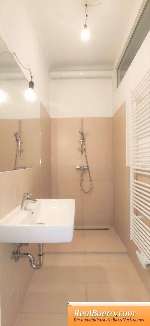 Badezimmer mit Dusche, Handwaschwaschbecken, Handtuchtrockner