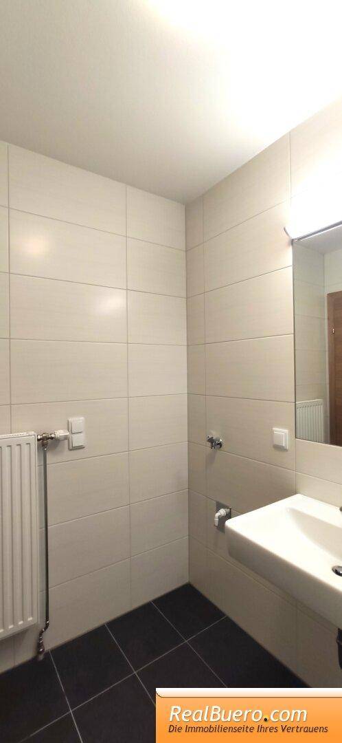 Badezimmer mit Dusche, Handwaschwaschbecken, Waschmaschinenanschuss
