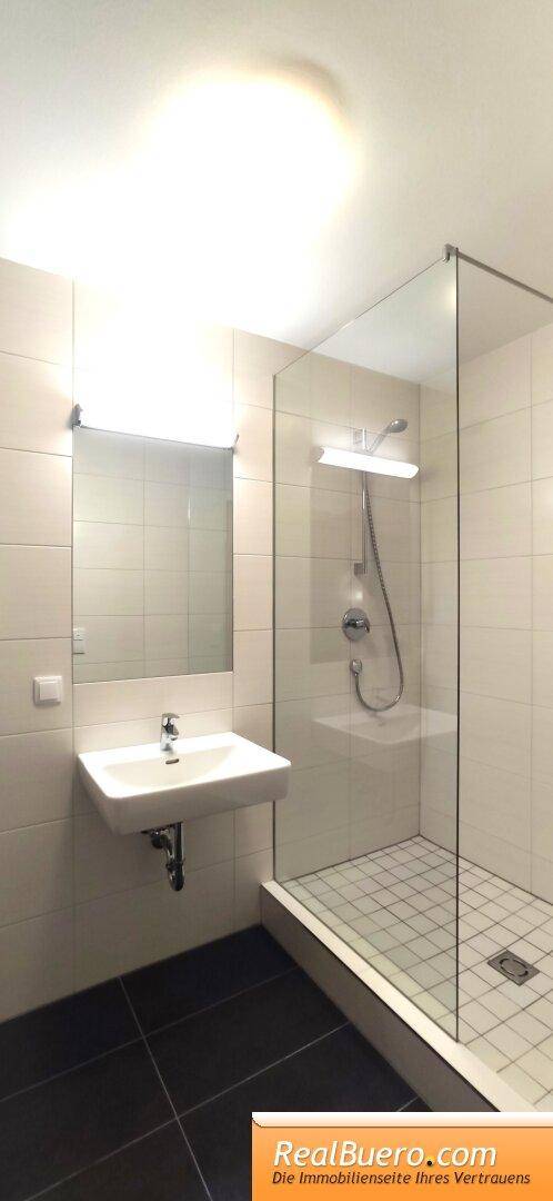 Badezimmer mit Dusche, Handwaschwaschbecken, Waschmaschinenanschuss