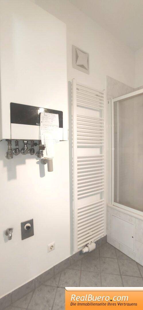 Badezimmer mit Wanne, Handwaschbecken, Waschmaschinenanschluss, Handtuchtrockner