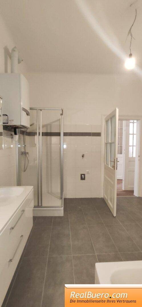 Badezimmer mit Doppelhandwaschbecken, Wanne, Dusche, Waschmaschinenanschluss