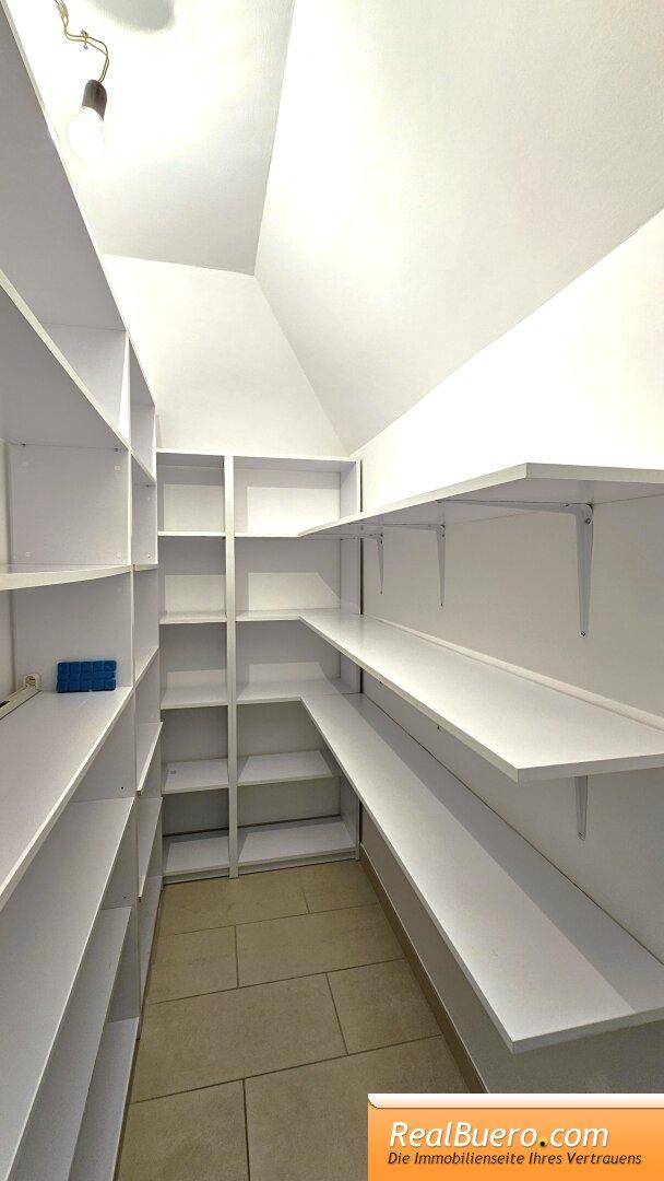 Praktische Speisekammer mit vielen weißen Regalen für zusätzlichen Stauraum.