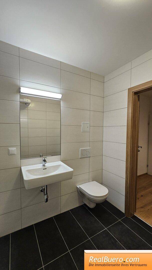 Bad mit Dusche, Toilette, Handwaschbecken, Handtuchtrockner und Waschmachinenanschluss