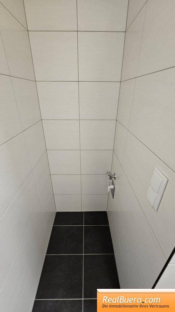 Bad mit Dusche, Toilette, Handwaschbecken, Handtuchtrockner und Waschmachinenanschluss