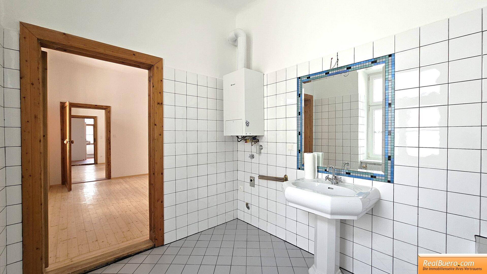 Badezimmer mit Wanne, Handwaschbecken, Waschmaschinenanschluss und Fenster