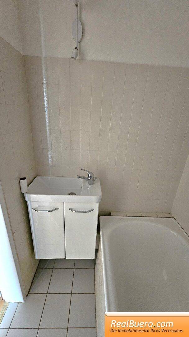 Badezimmer mit Handwaschbecken, Wanne und Toilette