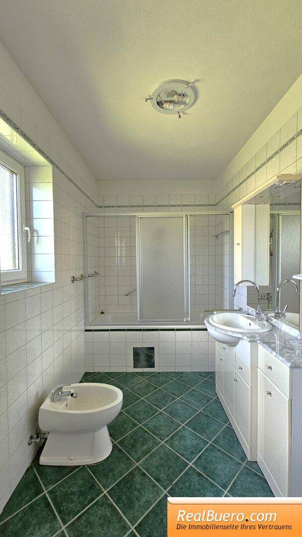 Badezimmer mit Wanne, Toilette, Bidet, Handtuchtrockner und Handwaschbecken