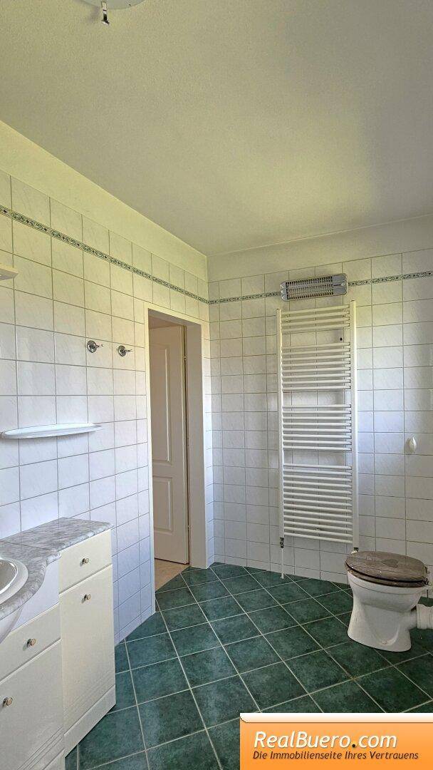 Badezimmer mit Wanne, Toilette, Bidet, Handtuchtrockner und Handwaschbecken