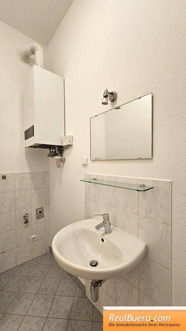 Badezimmer mit Dusche, Handwaschbecken, Waschmaschinenaschluss und Toilette