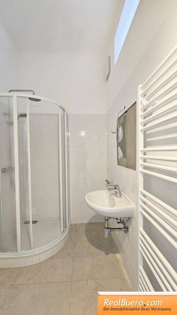 Badezimmer mit Dusche Handwaschbecken Toilette und Waschmaschinenanschluss