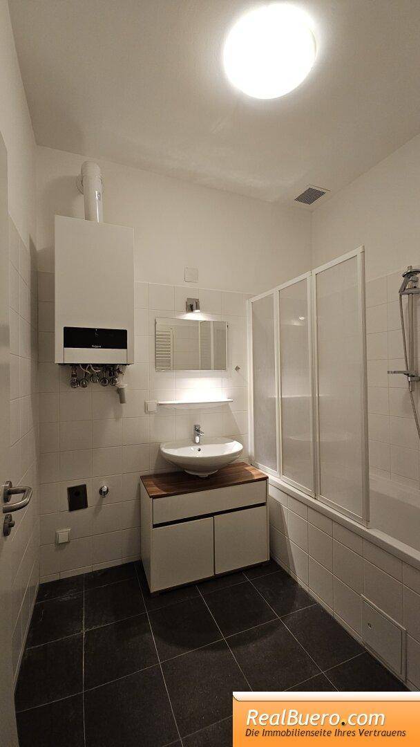 Badezimmer mit Wanne, Handwaschbecken, Waschmaschinenanschluss,