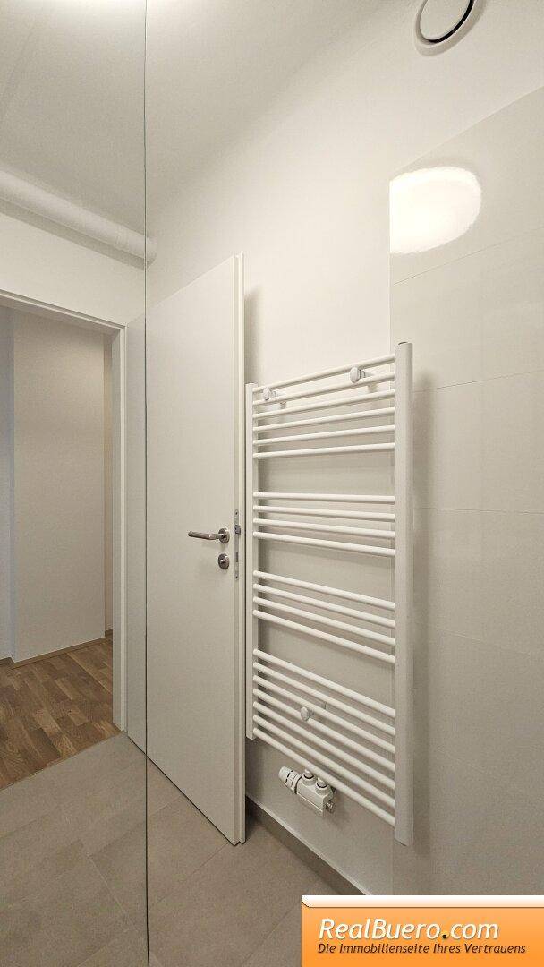 Badezimmer mit Dusche, Handwaschbecken und Waschmaschinenaschluss
