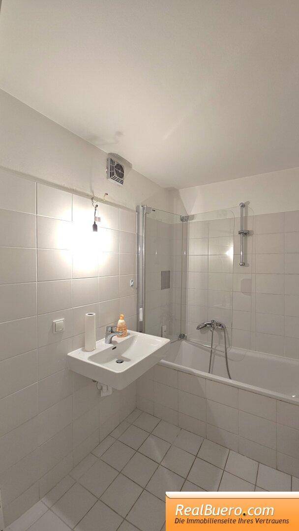 Badezimmer mit Wanne, Handwaschbecken, Waschmaschinenanschluss, Handtuchtrockner