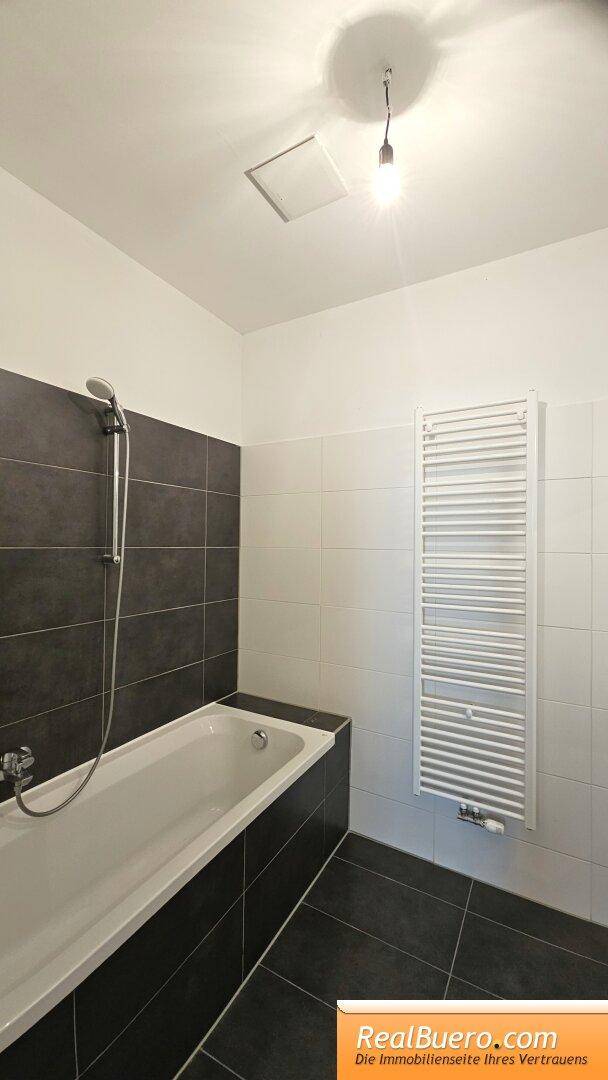 Badezimmer mit Wanne, Handwaschbecken, Waschmaschinenanschluss, Handtuchtrockner
