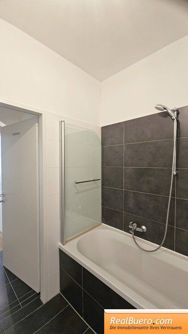 Badezimmer mit Wanne, Handwaschbecken, Waschmaschinenanschluss, Handtuchtrockner