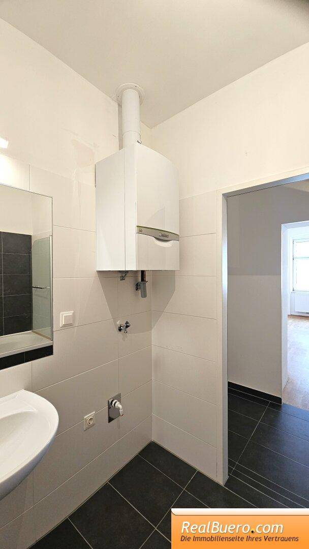 Badezimmer mit Wanne, Handwaschbecken, Waschmaschinenanschluss, Handtuchtrockner