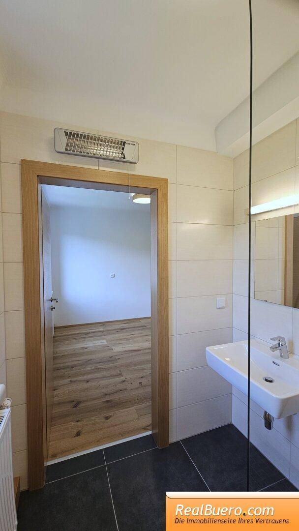 Badezimmer mit Dusche und Handwaschbecken