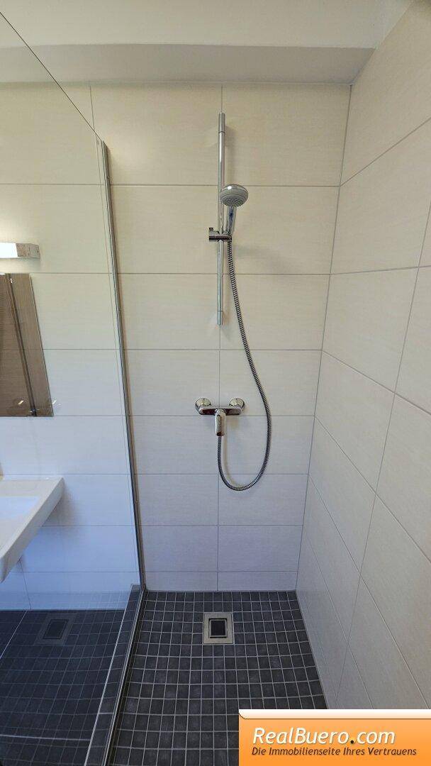 Badezimmer mit Dusche und Handwaschbecken