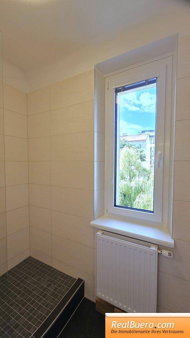 Badezimmer mit Dusche und Handwaschbecken