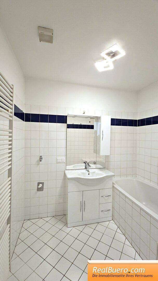 Badezimmer mit Wanne, Handwaschbecken, Waschmaschinenanschluss, Handtuchtrockner