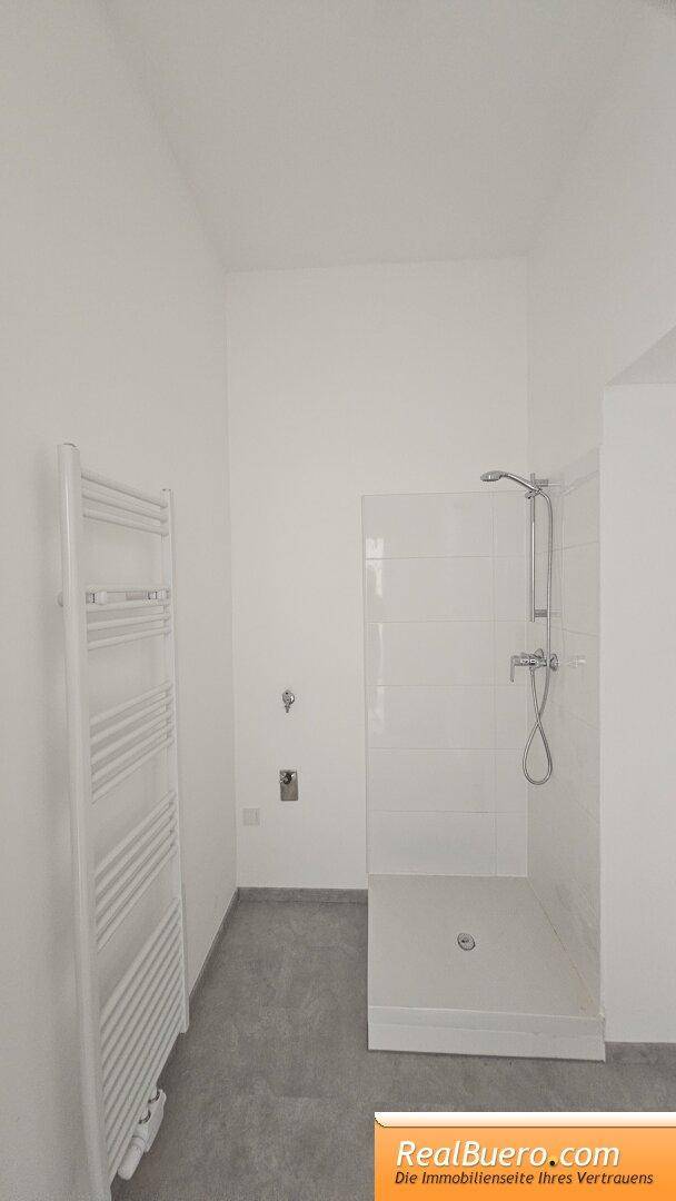 Badezimmer mit Dusche, Handwaschbecken, Handtuchtrockner, Waschmaschinenaschluss