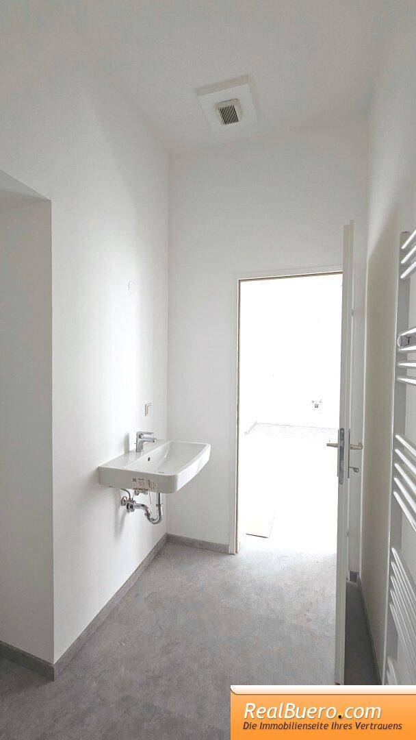 Badezimmer mit Dusche, Handwaschbecken, Handtuchtrockner, Waschmaschinenaschluss