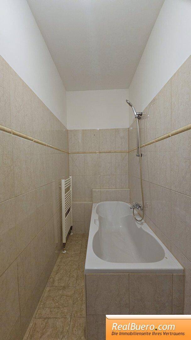 Badezimmer mit Wanne, Toilette, Handwaschbecken, Waschmaschinenanschluss