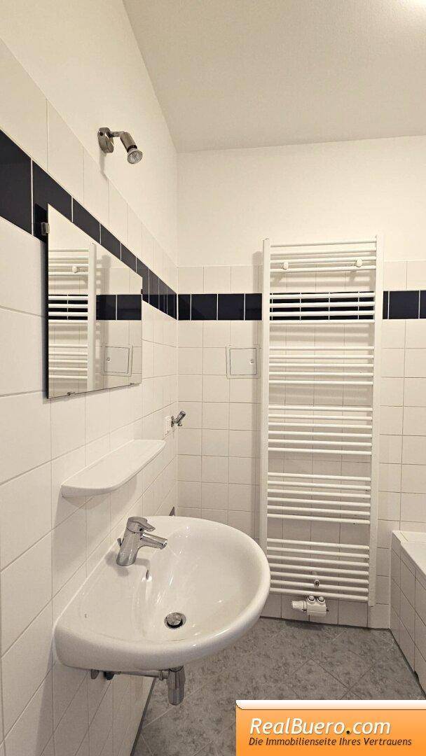 Badezimmer mit Wanne, Handwaschbecken, Waschmaschinenanschluss, Handtuchtrockner
