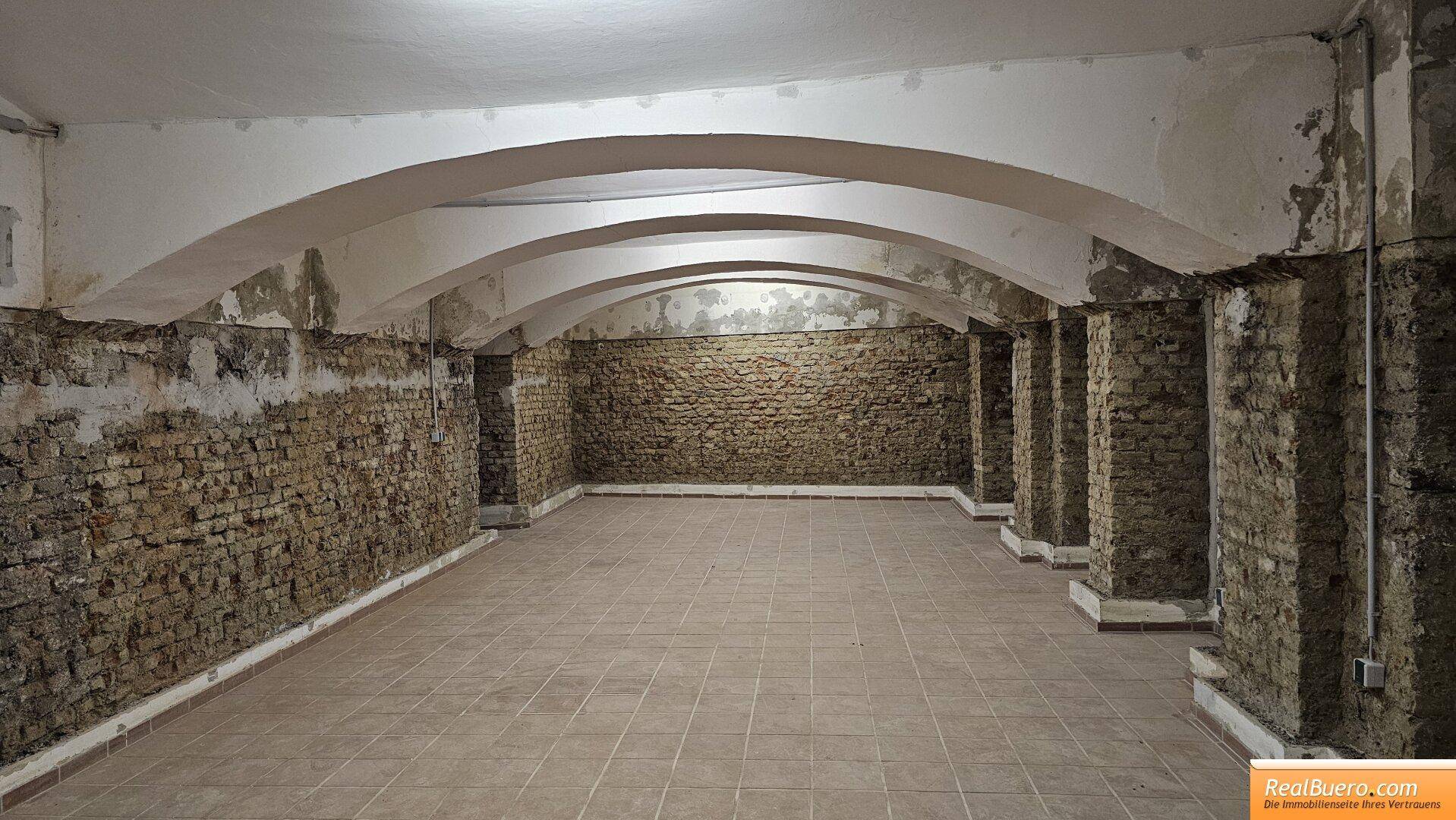 Geräumiger Kellerbereich mit markanten Gewölbedecken und rustikalen Ziegelwänden, ideal für Lagerung oder Ausbau.