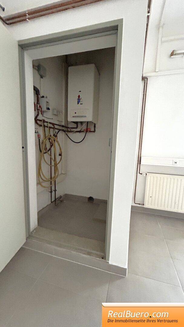 Technikraum mit Heizungsanlage und sichtbaren Rohren, funktional und gut zugänglich.