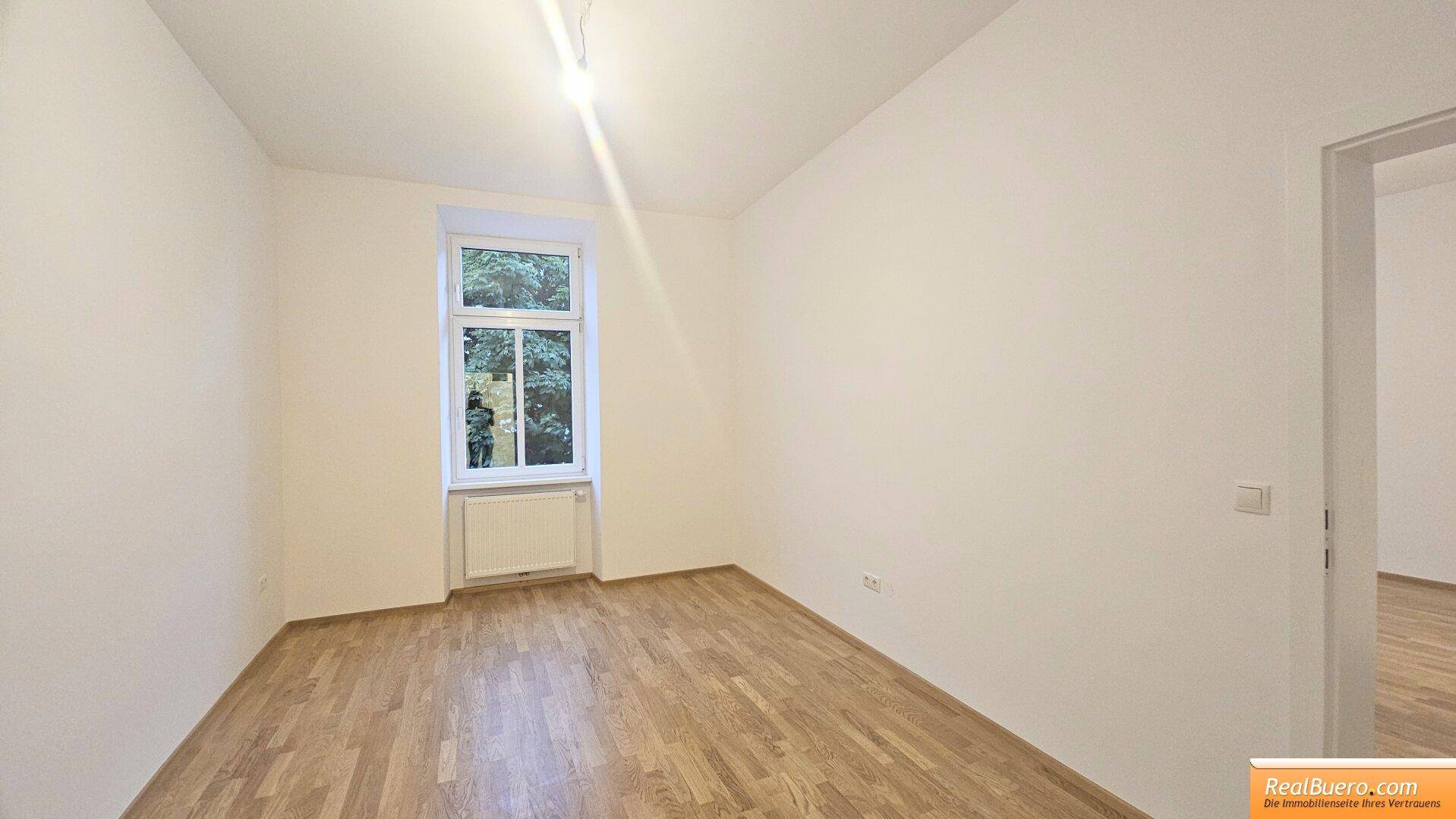 Gemütliches Zimmer mit Parkettboden und einem Fenster, geeignet als Schlaf- oder Arbeitszimmer.