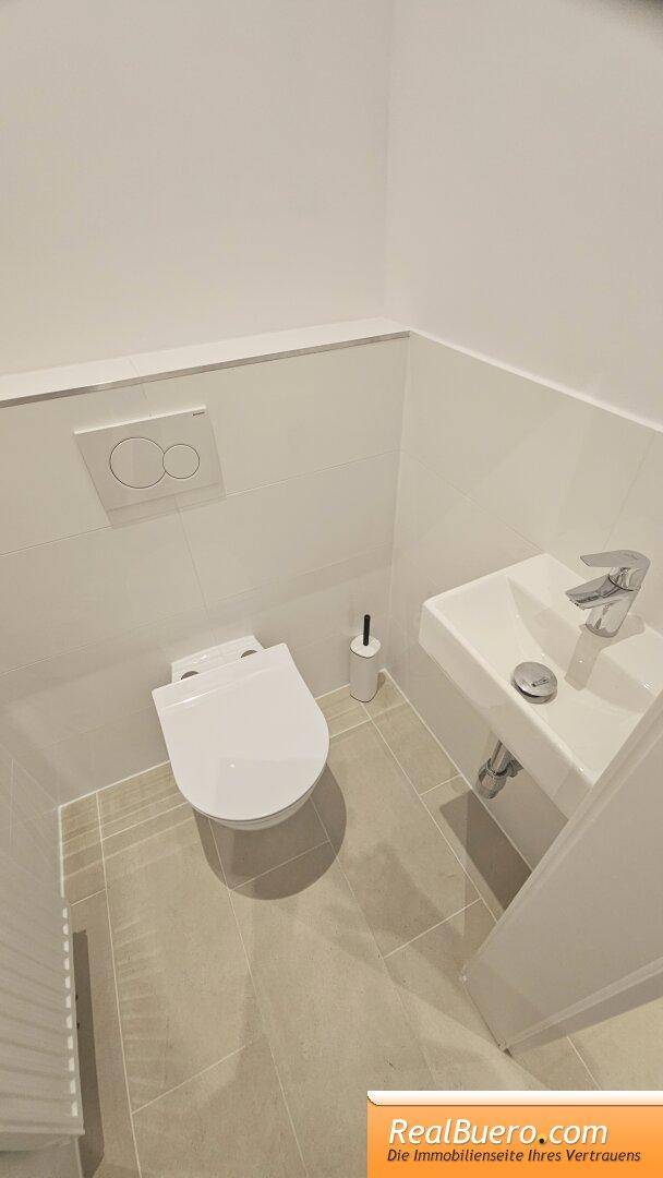 Kleines Gäste-WC mit wandhängender Toilette und kompaktem Waschbecken, praktisch und modern.