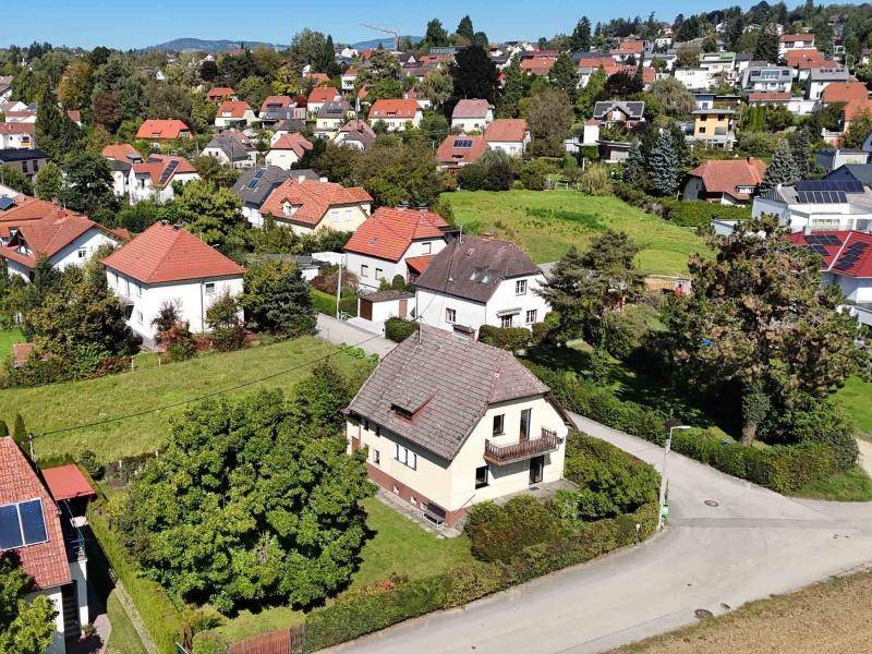 Luftaufnahme des Einfamilienhauses mit großem Grundstück und angrenzender Wohnbebauung.