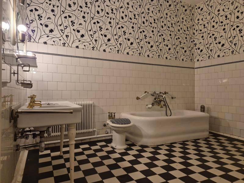 Klassisches Badezimmer mit schwarz-weißem Schachbrettmuster auf dem Boden und einer freistehenden Badewanne.