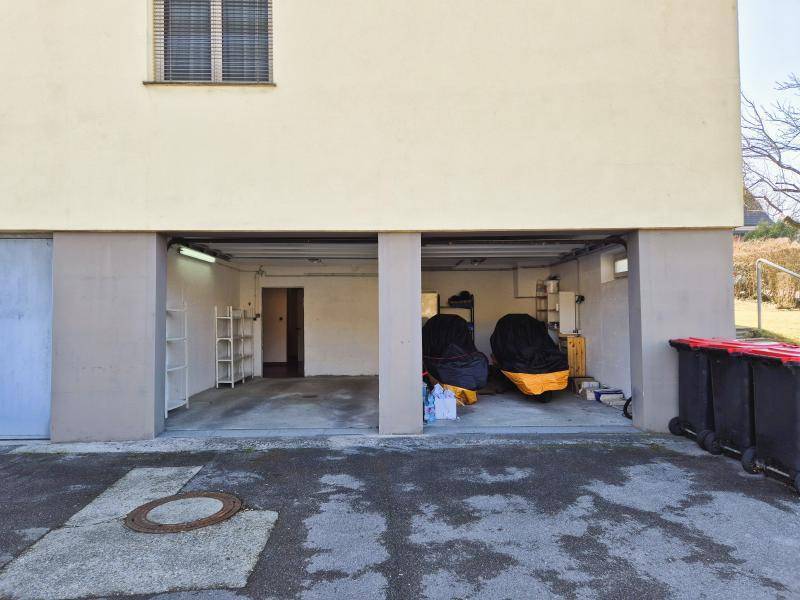 Offene Garagenbereiche im Untergeschoss des Gebäudes, teilweise als Lager genutzt.