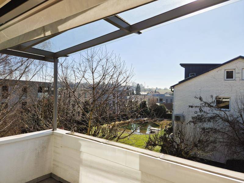 Überdachter Balkon mit Glasdach und weitem Blick über die Umgebung.