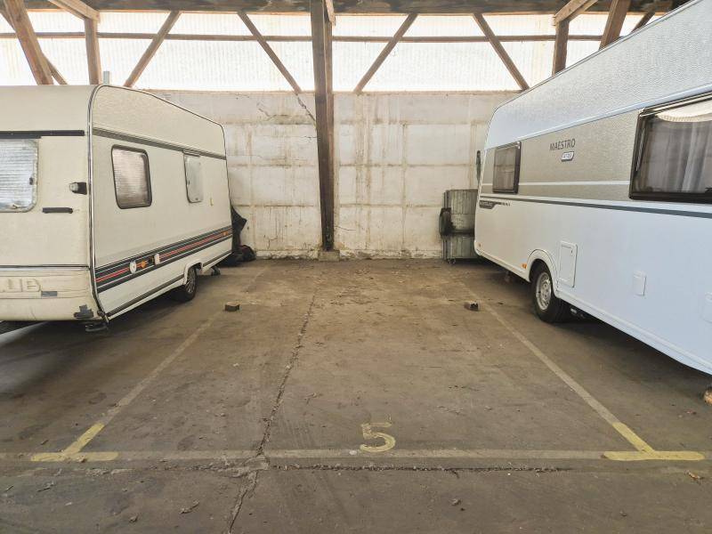 Stellplatz Nummer 5 in der Lagerhalle mit zwei Wohnwagen und rustikaler Holzbalkenkonstruktion.