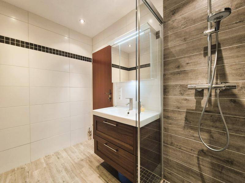 Modernes Badezimmer mit begehbarer Dusche, Holzoptikfliesen und schwebendem Waschtisch.