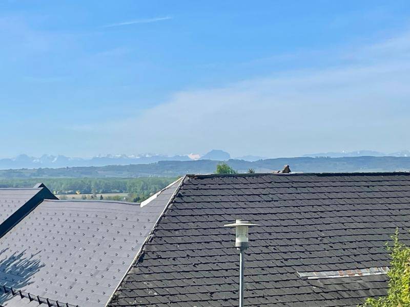 Dunkles Ziegeldach mit Straßenlaterne und beeindruckendem Fernblick auf die Berglandschaft.