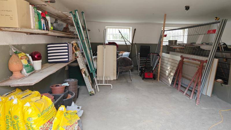 Geräumiger Abstellraum mit Regalen, Gartengeräten und verschiedenen Lagerartikeln.