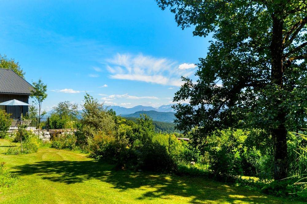 Großer, gepflegter Garten mit Rasenfläche und weitem Blick auf die malerische Bergkulisse.