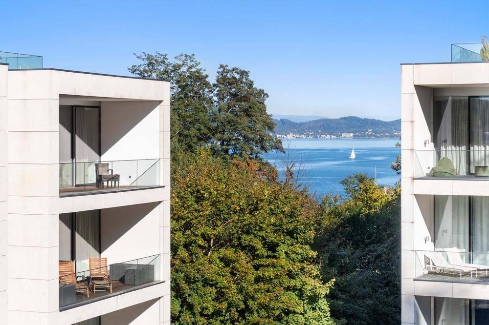 Balkone mit Glasbrüstung bieten einen malerischen Blick auf den See und die umliegende Landschaft.