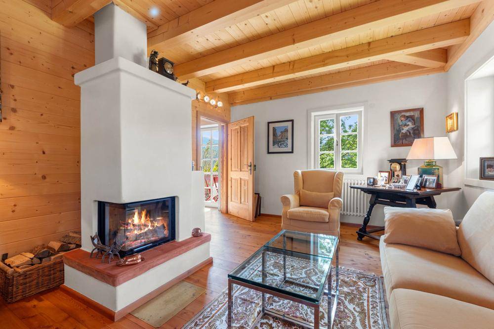 Gemütliches Wohnzimmer mit Holzbalkendecke, Kamin und traditionellen Möbeln.