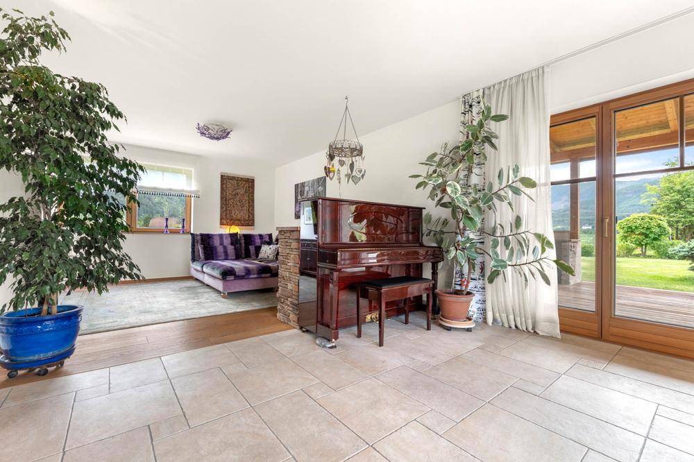 Geräumiges Wohnzimmer mit Klavier, bequemer Sitzecke und Zugang zur Terrasse.